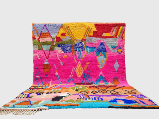Colorful handmade Moroccan wool rug with bold geometric Berber pattern in pink, blue, and yellow