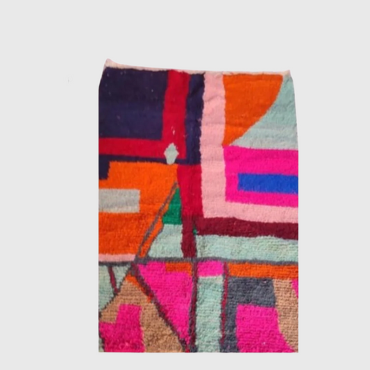 Vibrant handmade Moroccan wool rug with bold abstract boho patterns in pink, orange, blue, and red tones.