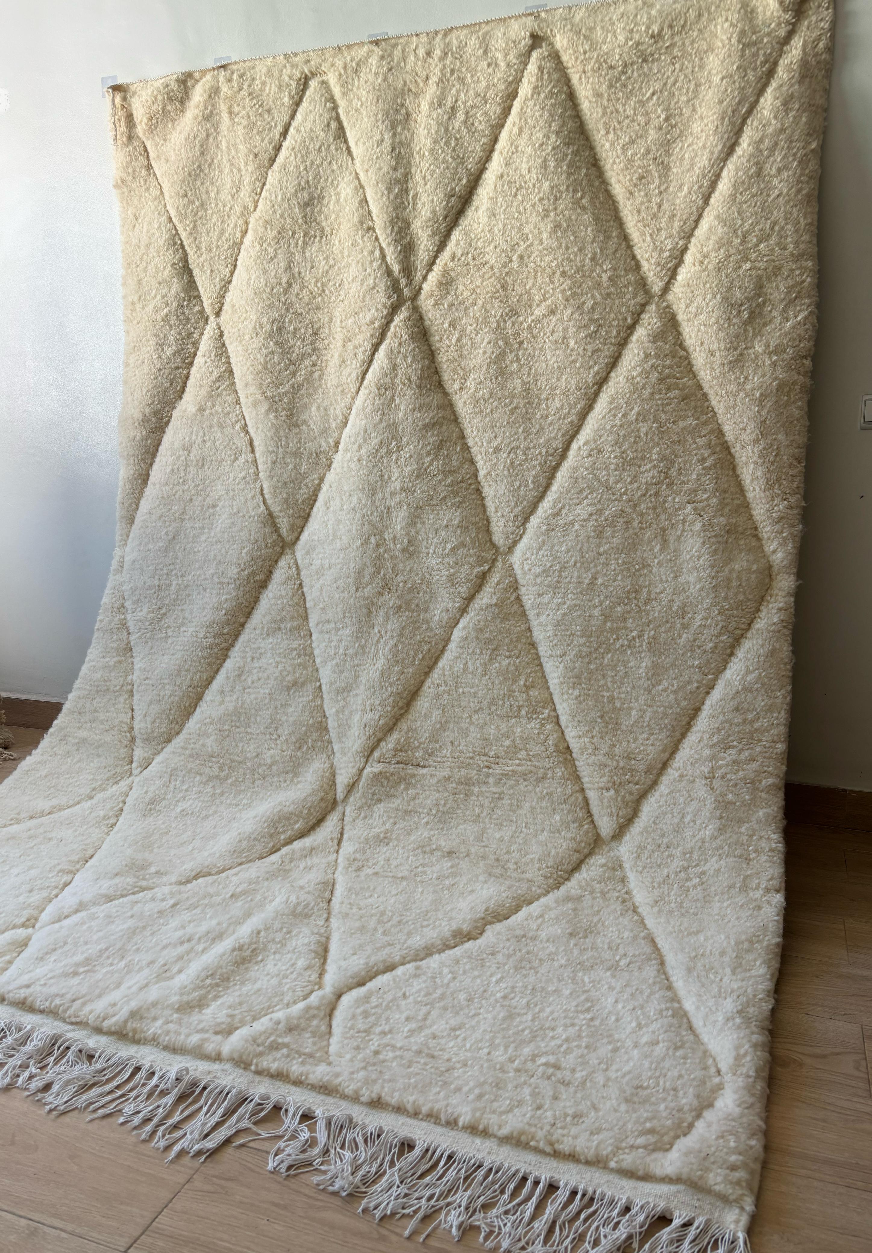 Handmade Moroccan wool rug in cream with subtle stitched diamond texture, styled with natural lighting on wood floor, 5x8 feet
