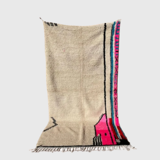 Handmade Moroccan boho wool rug with minimalist beige background and bold pink and blue design along the edge, 5x8 feet