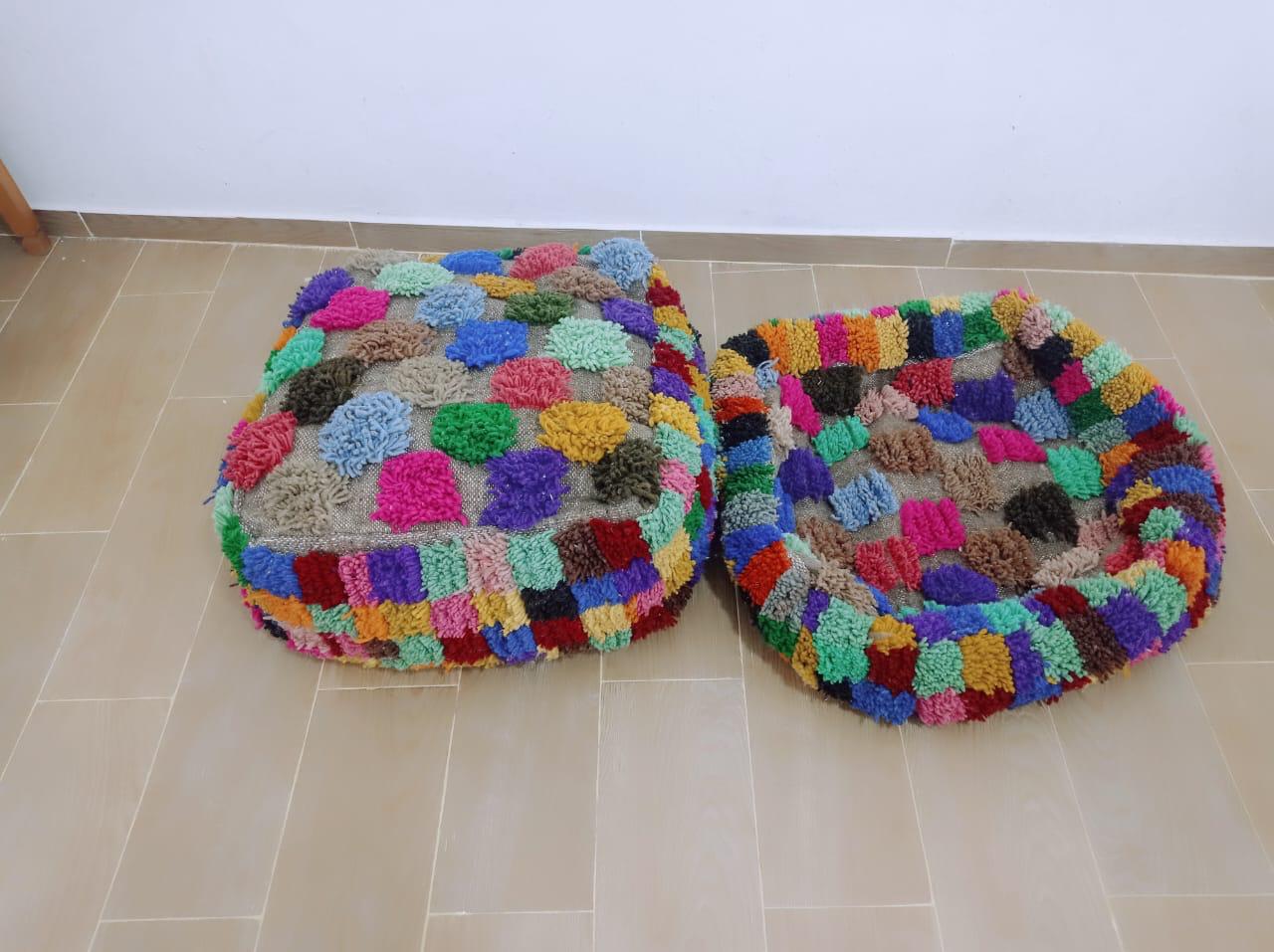 Set of two handmade Moroccan poufs crafted from colorful wool with a boho-style patchwork pattern.