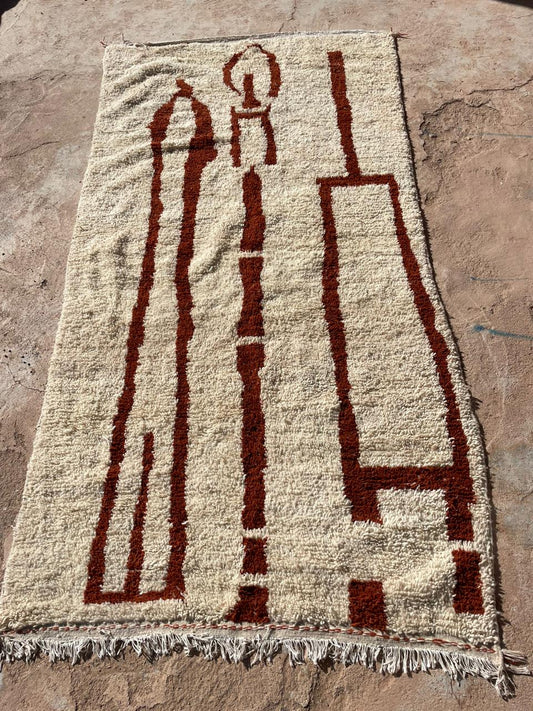 Outdoor photo of handmade Moroccan wool rug in beige with bold red abstract minimalist pattern, 4x6 feet
