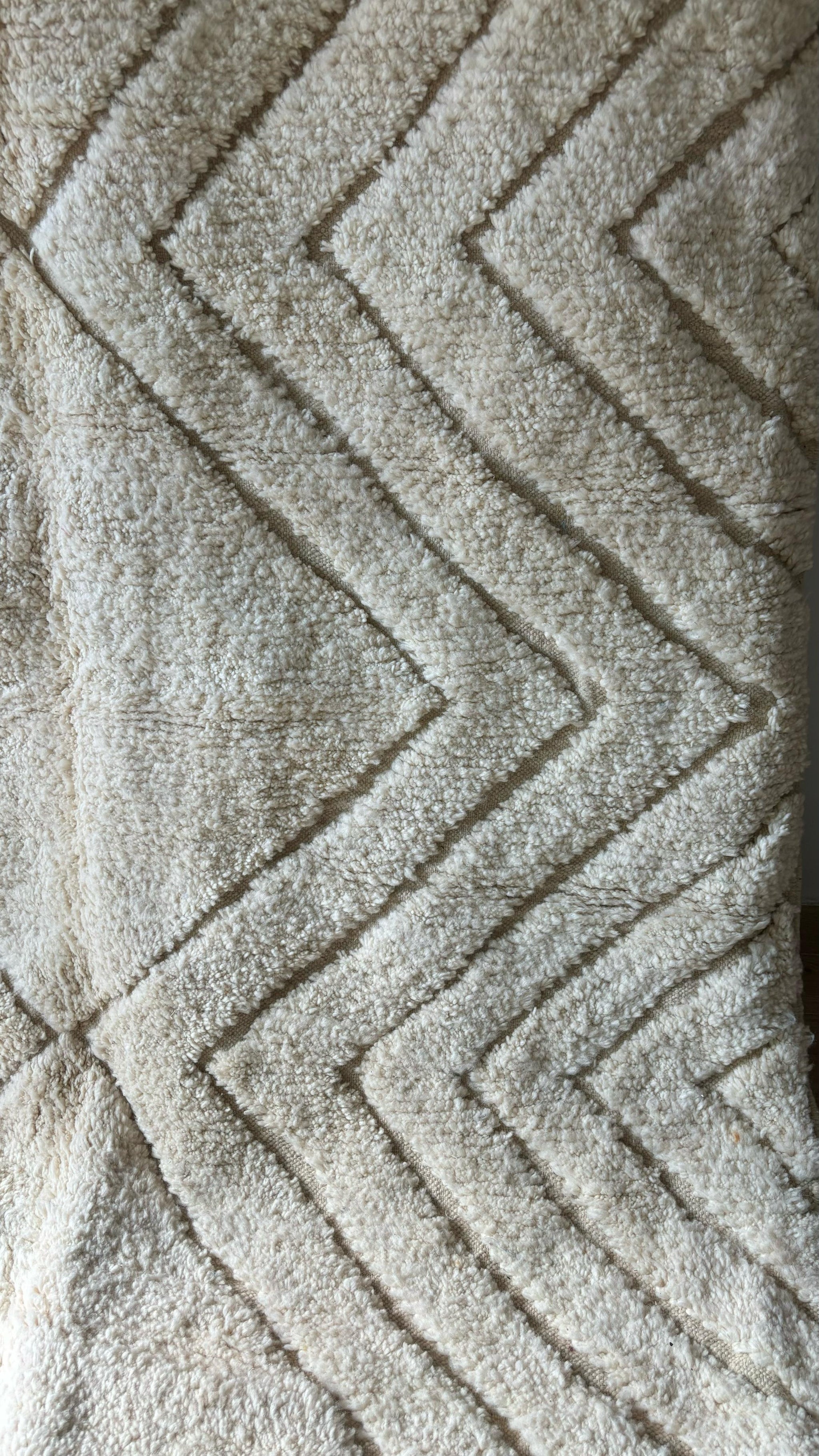 Detailed close-up of cream Moroccan rug with chevron pattern and plush texture