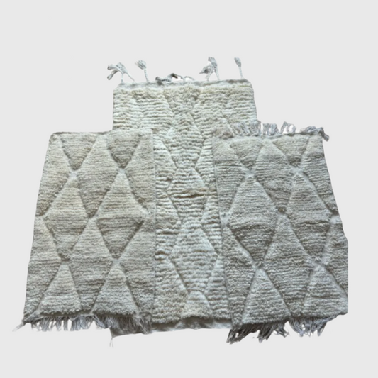 Set of handmade Moroccan wool rugs in cream with diamond pattern, shown as collection