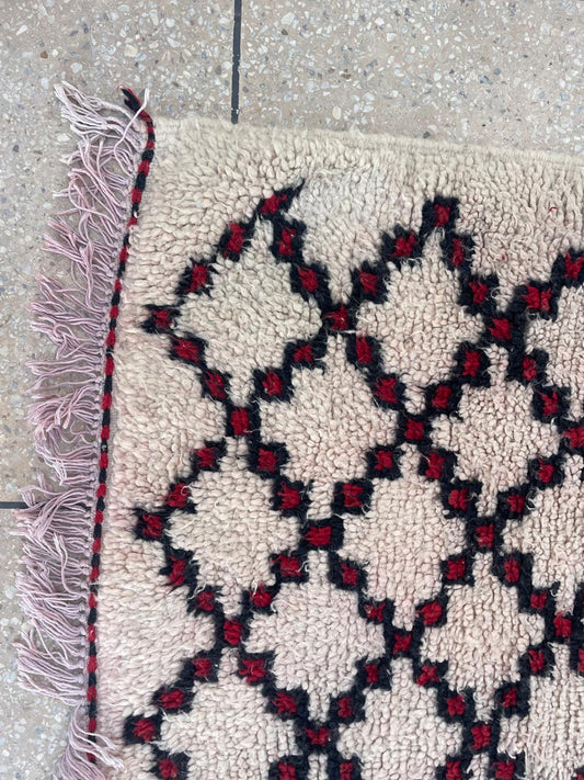 Close-up of Moroccan runner rug with black and burgundy Berber diamond pattern and wool texture